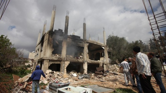 فلسطينيون يقفون امام بيت معتز وشاحة الذي قتل في هجوم للجيش الاسرائيلي على بيته في بير زيت 27 فبراير 2014 (أ ف ب)