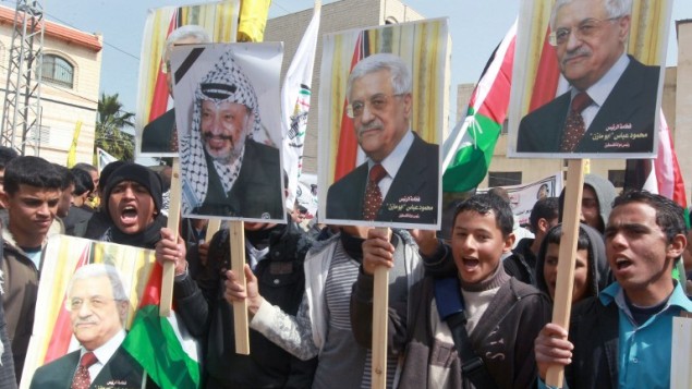 متظاهرون فلسطينيون يحملون صور الرئيس محمود عباس والرئيس الراحل ياسر عرفات دعما لعباس قبيل لقائه مع الرئيس الامريكي باراك أوباما في واشنطن 16 مارس 2014 (بعدسة جفار عشتيّة / أ ف ب)