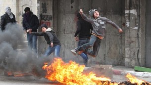 اشتباكات بين فلسطينيون والجيش الاسرائيلي (غير مرئي في الصورة) في الخليل ١٧ مارس ٢٠١٤ (بعدسة حازم بدر/ أ ف ب)