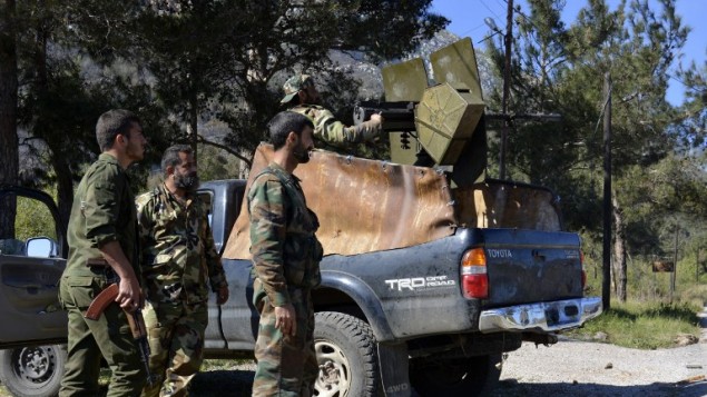 جنود موالون للنظام السوري يطلقون النار على قوات المعارضة، 27 مارس 2014 في قرية كسب اللاذقية (AFP PHOTO/STR)