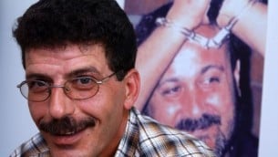 قدورة فارس، وزير فلسطيني سابق والرئيس الحالي لنادي السجناء الفلسطينيين امام صورة لمروان برغوثي (فلاش 90)