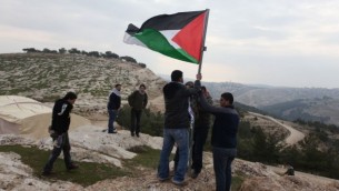 نشطاء فلسطينيون ينصبون العلم الفلسطيني في منطقة إي ١ شرقي القدس والتي هي جزء من منطقة سي (بعدسة عصام ريماوي/ فلاش ٩٠)