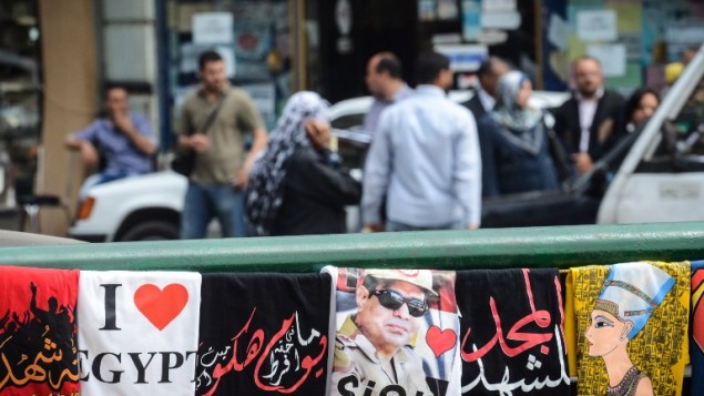قمصان، واحد يحمل صورة لقائد الجيش المتقاعد والمرشح الرئاسي عبد الفتاح السيسي (C) معروضة للبيع في الشارع في 13 أبريل عام 2014 في العاصمة المصرية القاهرة. AFP PHOTO / محمد الشاهد