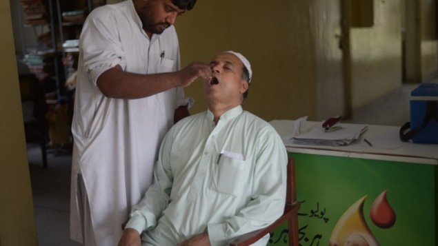 20 مايو,2014، المقيم الباكستاني محمد شريف مالك يتلقى قطرات التطعيم ضد شلل الأطفال من عامل صحي قبل السفر إلى المملكة العربية السعودية أعلنت منظمة الصحة العالمية "الصحة العامة في حالات الطوارئ" في بداية مايو 2014 بعد أن بدأت حالة جديدة من شلل الأطفال تطفو على السطح وتنتشر عبر الحدود AFP PHOTO/Farooq NAEEM 20 مايو,2014، المقيم الباكستاني محمد شريف مالك يتلقى قطرات التطعيم ضد شلل الأطفال من عامل صحي قبل السفر إلى المملكة العربية السعودية أعلنت منظمة الصحة العالمية "الصحة العامة في حالات الطوارئ" في بداية مايو 2014 بعد أن بدأت حالة جديدة من شلل الأطفال تطفو على السطح وتنتشر عبر الحدود AFP PHOTO/Farooq NAEEM