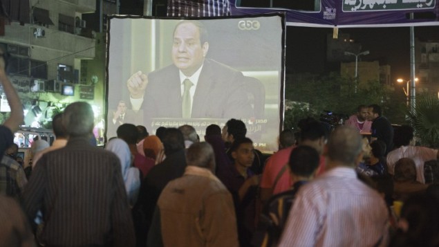 المصريون امام شاشت تعرض مقابلة مع قائد الجيش المصري عبد الفتاح كان السيسي في وسط القاهرة يوم 5 مايو 2014 . AFP PHOTO / خالد دسوقي