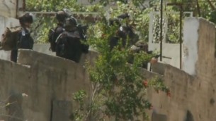 جندي إسرائيلي مشيرا بندقيته على مجموعة من الفلسطينيين أثناء مظاهرة يوم النكبة في بلدة بالضفة الغربية بيتونية  15 مايو. (صورة شاشة سي ان ان)