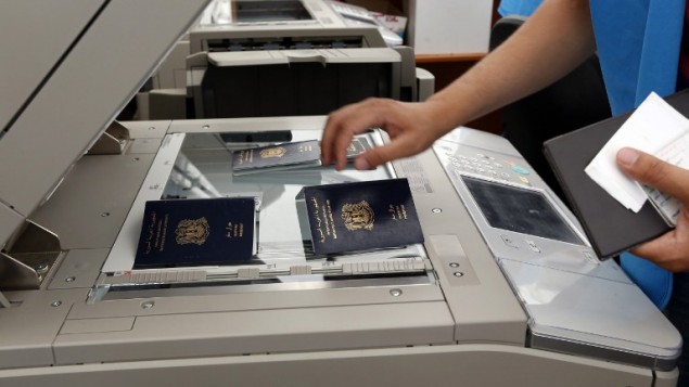 موظف وكالة الأمم المتحدة للاجئين  بفحص جوازات سفر للاجئين السوريين في مركز تسجيل اللاجئين، في ميناء مدينة طرابلس الشمالية  29 مايو 2014 و 31   
 AFP PHOTO/ANWAR AMRO