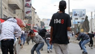 اطفال يرمون الحجارة بجانب حاجز قلندية في ذكرى النكبة (Nati Shohat/Flash90)