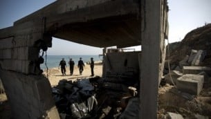 أفراد الأمن الفلسطينية يقومون بتفتش منزل هدم جراء الغارات الجوية الإسرائيلية خلال الليل في وسط قطاع غزة  28 يونيو 2014 ( AFP PHOTO / MAHMUD HAMS).