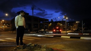 اسرائيلي يقف بجانب حفرة الناجمة عن صاروخ أطلق من قطاع غزة، في مدينة سديروت الاسرائيلية في النقب الغربي الأربعاء 12 مارس، 2014 AFP/David Buimovitch