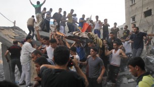 فلسطينيون يحملون جثة المقتولمن عائلة  غنام، بعد إزالتها من تحت أنقاض منزلهم بعد غارة جوية اسرائيلية على رفح في جنوب قطاع غزة، في 11 تموز 2014 AFP PHOTO / SAID KHATIB