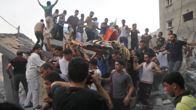 فلسطينيون يحملون جثة المقتولمن عائلة  غنام، بعد إزالتها من تحت أنقاض منزلهم بعد غارة جوية اسرائيلية على رفح في جنوب قطاع غزة، في 11 تموز 2014 AFP PHOTO / SAID KHATIB