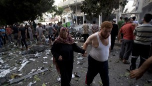 فلسطينيون يتفقدون موقع غارة جوية اسرائيلية في مدينة غزة  11 يوليو 2014. AFP PHOTO / MOHAMMED ABED
