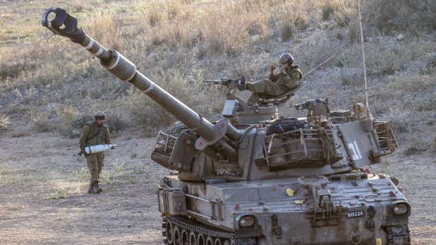 جندي إسرائيلي يحمل قذيفة دبابة 155mm بالقرب من الحدود الإسرائيلية مع قطاع غزة 14 يوليو 2014. AFP PHOTO / JACK GUEZ جندي إسرائيلي يحمل قذيفة دبابة 155mm بالقرب من الحدود الإسرائيلية مع قطاع غزة 14 يوليو 2014. AFP PHOTO / JACK GUEZ