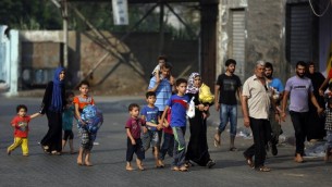 فلسطينيون يتركون بيوتهم في حي الشجاعية بعد القصف الإسرائيلي الثقيل 20 يوليو 2014 AFP PHOTO / MOHAMMED ABED