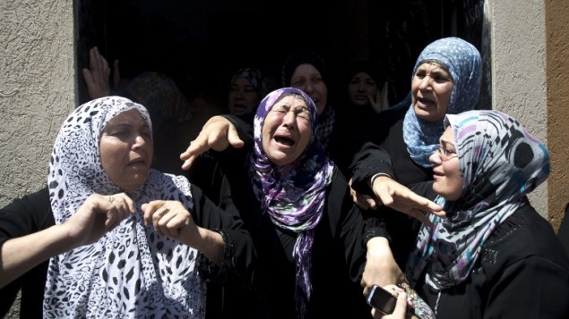 نساء فلسطينيات يبكين  حدادا خلال جنازة حافظ حماد، أحد كبار قادة الجهاد الإسلامي، وخمسة من أفراد عائلته، بينهم امرأتان وطفلان، الذين قتلوا جميعا عندما سقطت قذيفة إسرائيلية في منزلهم في بلدة شمال قطاع غزة بيت حانون في 09 يوليو 2014  AFP PHOTO / MAHMUD HAMS