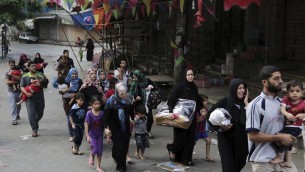 فلسطينيون يتركون بيوتهم في حي الشجاعية بعد القصف الإسرائيلي الثقيل 20 يوليو 2014 AFP PHOTO