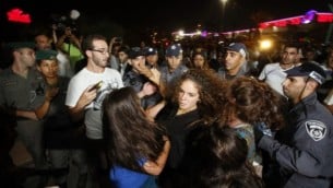 ناشطو المنظمة اليمينية لمنع الاستيعاب في الأراضي المقدسة (LEHAVA) اثناء اشتباكات مع الشرطة خلال مظاهرة خارج قاعة الزفاف حيث تزوج محمود منصور، العربي الإسرائيلي، من موريل مالكا، اليهودية الاصل، أغسطس 17،  2014 في ريشون لتسيون. AFP/GALI TIBBON
