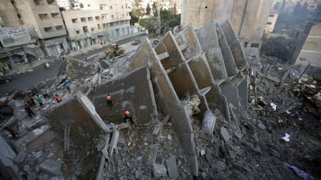 سكان فلسطينيون وعناصر الاسعاف يتفقدون بقايا المبنى الذي دمرته الغارات الاسرائيلية والتي اسفرت عن مقتل 2 واصابة 20, مدينة غزة 26 اغسطس 2014 AFP PHOTO/MAHMUD HAMS