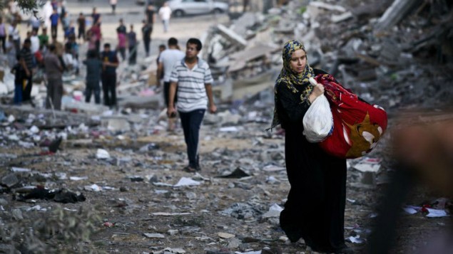 امرأة فلسطينية نازحة تأخذ بعض أمتعتها من منزلها 26 أغسطس 2014AFP/ROBERTO SCHMIDT امرأة فلسطينية نازحة تأخذ بعض أمتعتها من منزلها 26 أغسطس 2014AFP/ROBERTO SCHMIDT