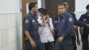 رجال الشرطة يرافقون يوسف حاييم بن دافيد, أحد المشتبه بهم اليهود في قتل القاصر محمد ابو خضير في المحكمة القطرية في القدس 6 أغسطس (يوناتان سنايدل/ فلاش 90)