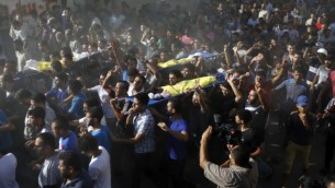 تشييع جنازة أربعة أولاد، من عائلة بكر، في مدينة غزة، 16 يوليو، 2014. أربعة قتلوا وأصيب عدد آخر بجروح في مخيم الشاطئ في غزة في قصف اسرائيلي  AFP/MOHAMMED ABED