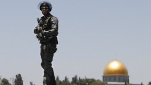 شرطي إسرائيلي يقف على سطح مبنى أمام قبة الصخرة في القدس الشرقية  4 يوليو 2014 (أحمد الغرابلي / أ ف ب)