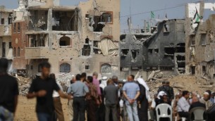 فلسطينيون في انتظار وصول رئيس الوزراء رامي حمد الله  خلال جولة لبعض المناطق الأكثر تضررا من حرب ال 50 يوما بين اسرائيل وقطاع غزة في شهري يوليو وأغسطس، حي الشجاعية مدينة غزة،  9 أكتوبر، 2014  Mohammed Abed/AFP