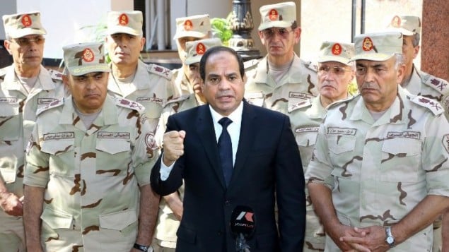 صورة مقدمة من مكتب الرئاسة المصرية  25 أكتوبر 2014  الرئيس عبد الفتاح السيسي مع الجنرالات العسكرية العليا، خلال مؤتمر صحفي بعد اجتماع طارئ للمجلس الأعلى للقوات المسلحة في القاهرة. حيث دخلت حالة الطوارئ حيز التنفيذ في معظم أنحاء شبه جزيرة سيناء المصرية بعد قتل 30 جنديا في تفجير سيارة مفخخة على يد من يشتبه بانهم جهاديين  AFP PHOTO / HO /EGYPTIAN PRESIDENCY