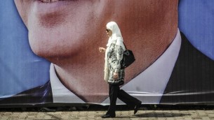 8 أغسطس 2014  امرأة  تمشي امام صورة حملة رئيس الوزراء التركي رجب طيب أردوغان في اسطنبول  AFP PHOTO/OZAN KOSE