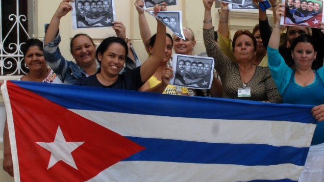 كوبيون يحتفلون مع العلم الوطني في كماغويه، 600 كلم شرق هافانا17 ديسمبر  2014، بعد إطلاق سراح واشنطن ثلاثة جواسيس كوبيين الذين كانوا في سجن أمريكي منذ عام 2001 AFP PHOTO / AIN - ROBERTO MOREJON