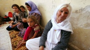 عائلة ايزيدية عراقية  فرت من العنف في بلدة سنجار شمال العراق، يحتمون في مدرسة بالمدينة الكردية دهوك في إقليم كردستان 5 أغسطس 2014. AFP/SAFIN HAMED