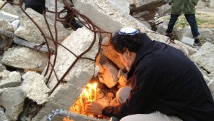 الحاخام اريك اشرمان رئيس جمعية حاخامات من اجل حقوق الانسان يضيء شمعدان فوق حطام بيت فلسطيني هدمته اسرائيل في قرية ديرات جنوب الضفة الغربية 22 ديسمبر 2014 (بعدسة الحانان ميلر)