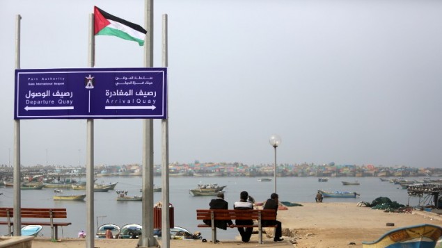 يافطة في ميناء غزة، مكتوب عليها ’رصيف المغادرة’ و’رصيف الوصول’ تحت شعار ’ميناء غزة الدولي’ 15 يناير 2015 (MAHMUD HAMS / AFP)