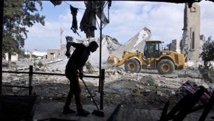 رجل فلسطيني يكنس مدخل بيته الذي تضرر بعد قصف مسجد قريب منه في بيت لاهيا، 25 اغسطس 2014 (AFP Photo/Roberto Schmidt)