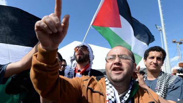 رجل فلسطيني يهتف امام علم فلسطين في المتدى الاجتماعي العالمي في تونس، 25 مارس 2015 (FADEL SENNA / AFP)