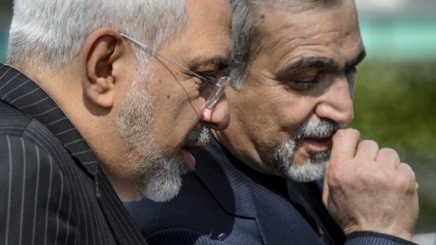 وزير الخارجية الايراني محمد جواد ظريف (L) يستمع لاحد موظفيه  بعد جلسة التفاوض على البرنامج للالنووي الإيراني في لوزان 27 آذار. AFP PHOTO / FABRICE COFFRINI