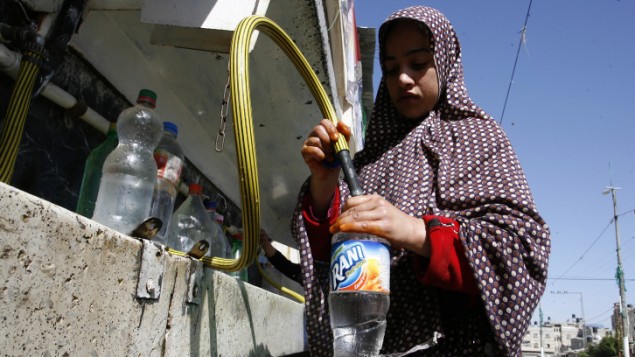 فتاة فلسطينية تعبئ المياه من منشأة الأونروا في مخيم اللاجئين رفح، جنوب قطاع غزة، 6 ابريل 2014 (Abed Rahim Khatib / Flash90)
