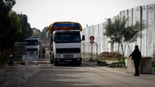 شرطي فلسطيني بجانب شاحنة تحمل الاسمنت، دخلت غزة من اسرائيل عن طريق معبر كرم ابو سالم في رفح، جنوب قطاع غزة، 25 نوفمبر 2014 (Abed Rahim Khatib / Flash90)