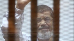 ارشيف - الرئيس المصري السابق محمد مرسي داخل قفص خلال محاكمته في القاهرة، 7 ديسمبر 2014 (AHMED RAMADAN / AFP)