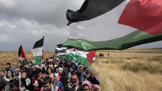 الالاف من مواطني اسرائيل العرب يحملون الأعلام الفلسطينية خلال مسيرة العودة السنوية من اجل حق العودة للاجئين الفلسطينيين الذين فروا من ديارهم أو طردوا خلال حرب عام 1948. مسيرة هذا العام الى قرية الحدثة بالقرب من طبريا في شمال إسرائيل،  23 أبريل عام 2015. AFP PHOTO / AHMAD GHARABLI