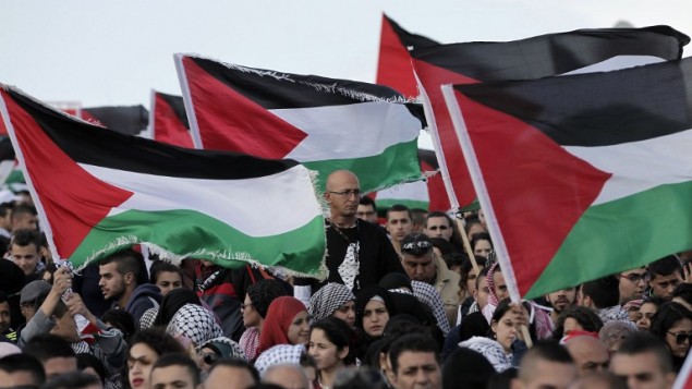 الالاف من مواطني اسرائيل العرب يحملون الأعلام الفلسطينية خلال مسيرة العودة السنوية من اجل حق العودة للاجئين الفلسطينيين الذين فروا من ديارهم أو طردوا خلال حرب عام 1948. مسيرة هذا العام الى قرية الحدثة بالقرب من طبريا في شمال إسرائيل،  23 أبريل عام 2015. AFP PHOTO / AHMAD GHARABLI