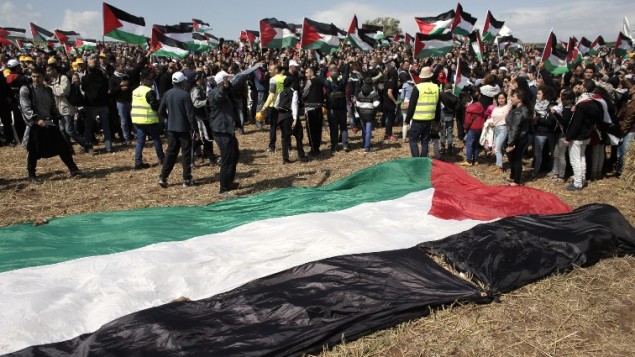 الالاف من مواطني اسرائيل العرب يحملون الأعلام الفلسطينية خلال مسيرة العودة السنوية من اجل حق العودة للاجئين الفلسطينيين الذين فروا من ديارهم أو طردوا خلال حرب عام 1948. مسيرة هذا العام الى قرية الحدثة بالقرب من طبريا في شمال إسرائيل،  23 أبريل عام 2015. AFP PHOTO / AHMAD GHARABLI