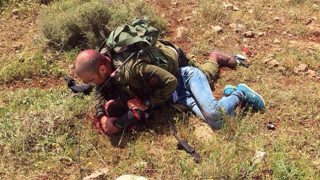 جندي إسرائيلي يسيطر على شاب فلسطيني قام بعطن جندي آخر بالقرب من الجدار الفاصل في الضفة الغربية، 2 ابريل، 2016. (IDF spokesperson) جندي إسرائيلي يسيطر على شاب فلسطيني قام بعطن جندي آخر بالقرب من الجدار الفاصل في الضفة الغربية، 2 ابريل، 2016. (IDF spokesperson)