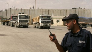 شرطي فلسطيني تابع لحماس يشرف على شاحنات تدخل مواد بناء الى قطاع غزة عن طريق معبر كرم ابو سالم، 22 سبتمبر 2013 (Abed Rahim Khatib/Flash90)