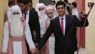 العروس الفلسطينية مروى موسى وعريسها احمد ابو سلامة يشاركان في حفل الزواج الجماعي في مدينة غزة، 11 ابريل 2015 (AFP/ MAHMUD HAMS)