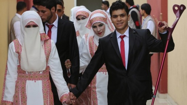 العروس الفلسطينية مروى موسى وعريسها احمد ابو سلامة يشاركان في حفل الزواج الجماعي في مدينة غزة، 11 ابريل 2015 (AFP/ MAHMUD HAMS)