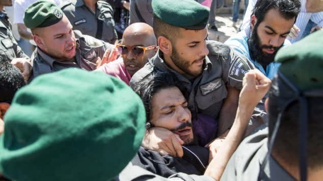 اعتقال متظاهر فلسطيني من قبل القوات الإسرائيلية خلال مسيرة العلم في البلدة القديمة في القدس، 17 مايو 2015 (AFP Photo/Jack Guez)