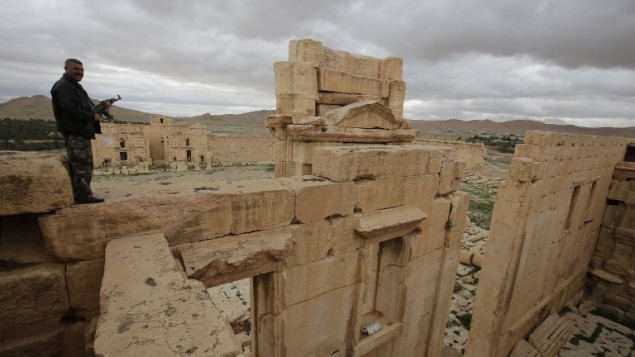 شرطي سوري يقف فوق معبد بعل في مدينة تدمر الأثرية في 14 مارس، 2014. (Joseph Eid/AFP)