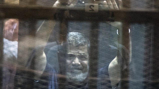 الرئيس المصري المخلوع محمد مرسي وراء قضبان السجن خلال اعلان حكم الاعدام الصادر بحقه وبحق 100 متهم آخرين 16 مايو 2016 AFP/KHALED DESOUKI